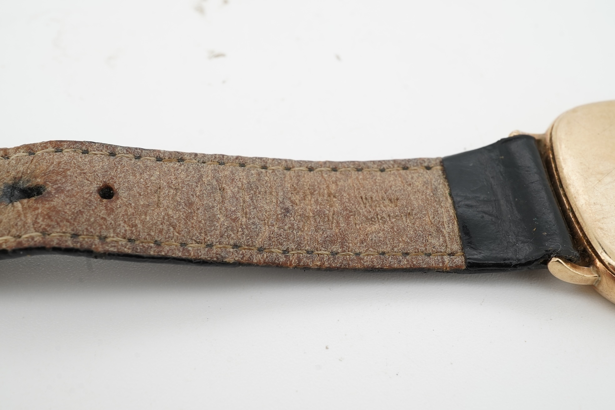 A gentleman's recent 9ct gold Rotary quartz wristwatch, with shaped square dial, baton numerals and date aperture, case diameter 30mm, part of associated leather strap missing.